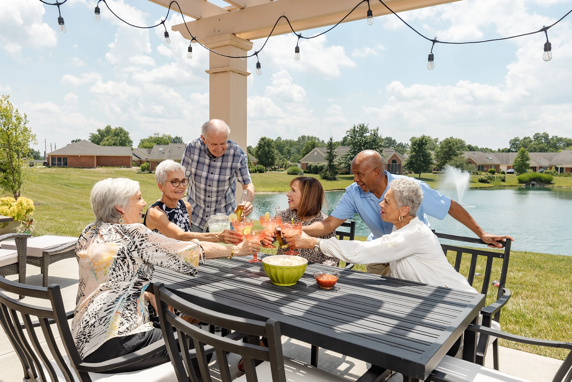 Berkeley Square residents socializing over lemonade in the gazebo outside by the pond.