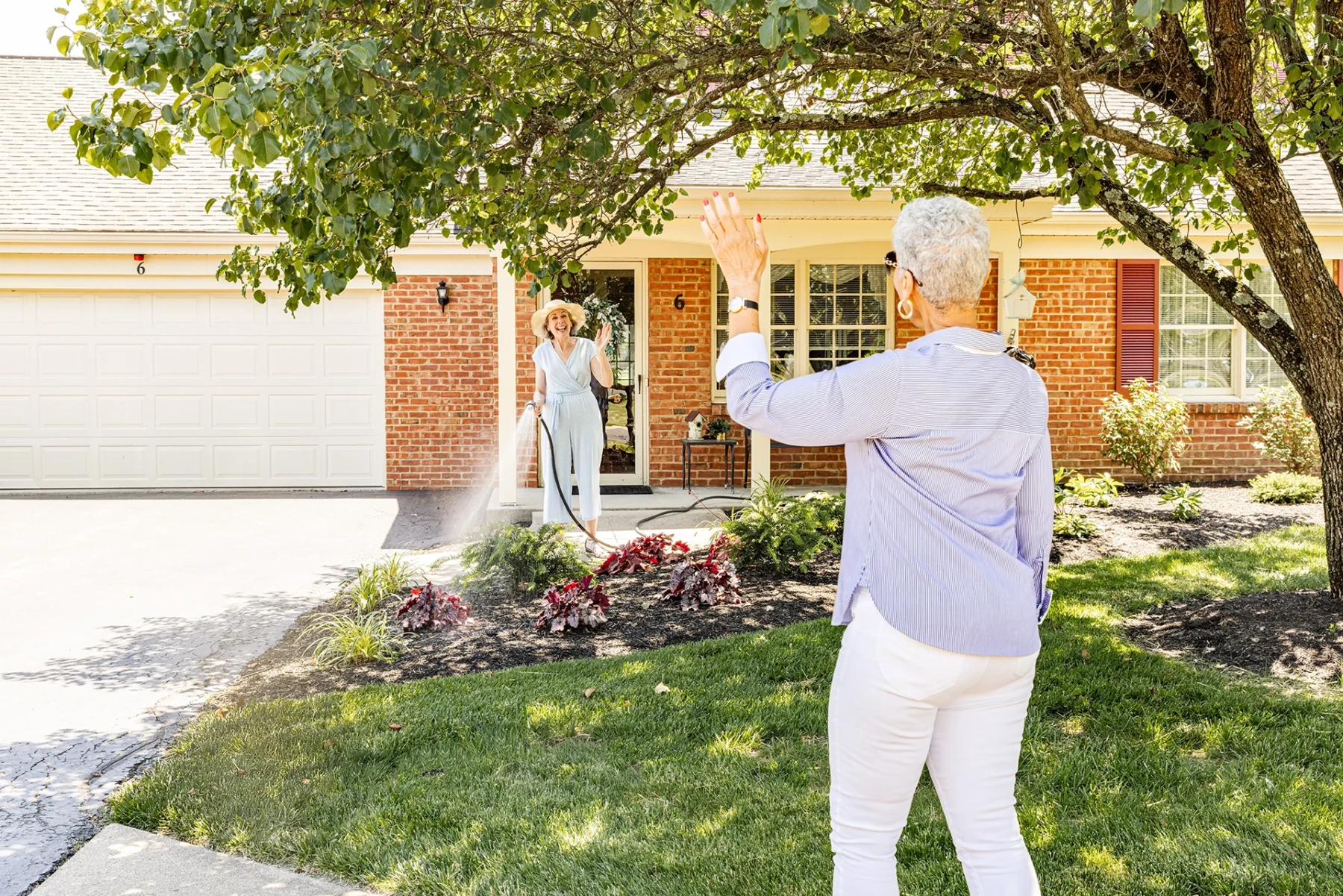 Berkeley Square senior living residents wave to each other by an independent living home