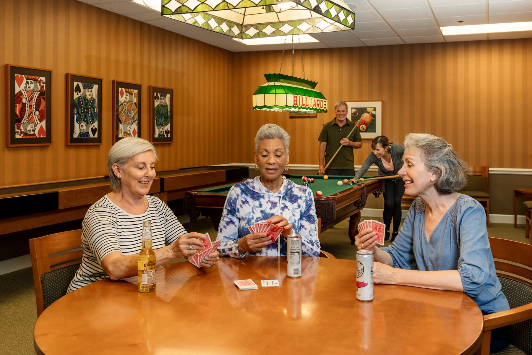 Berkeley Square senior living residents playing cards in the community Billiards Room