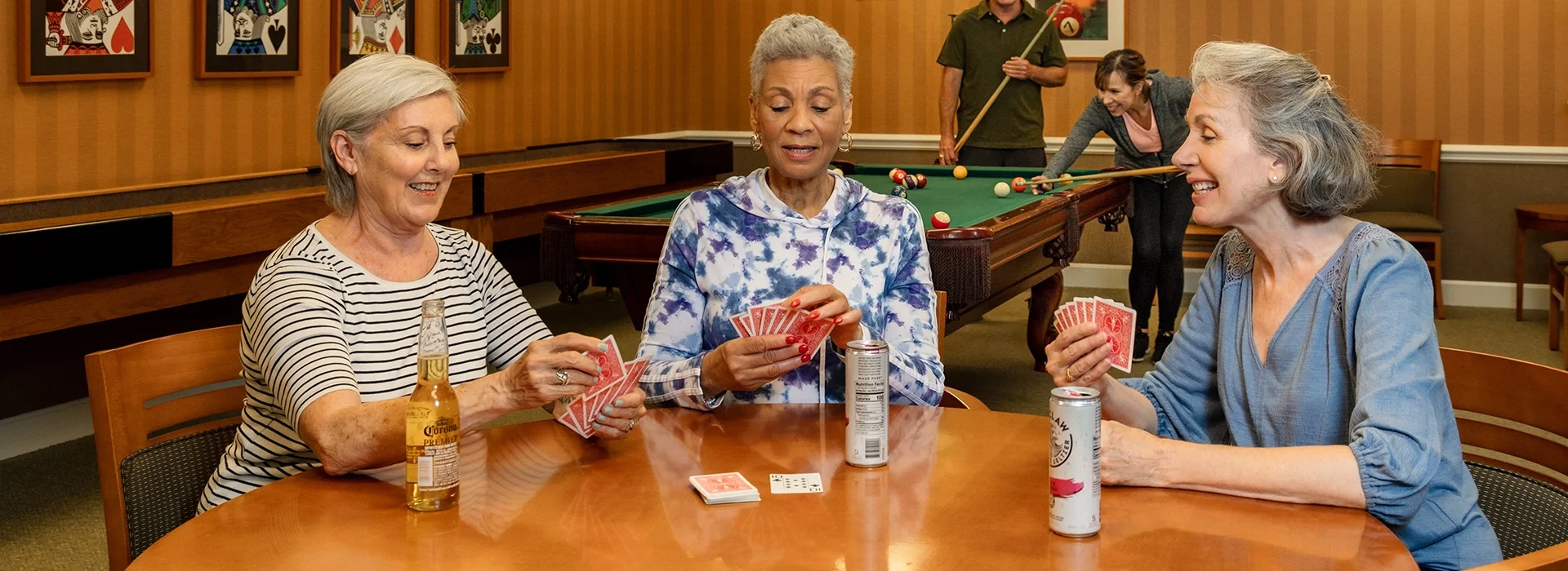 Community First Solutions senior living residents playing cards and enjoying drinks in the Billiards Room