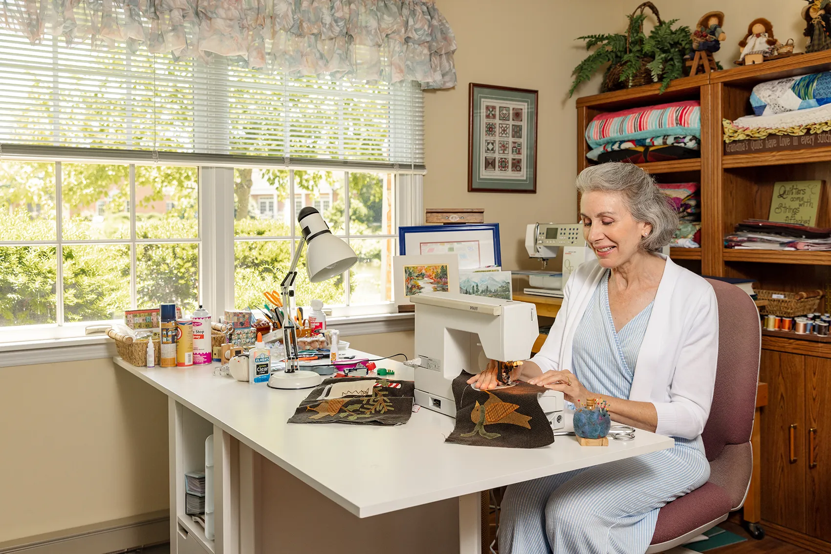 Community First Solutions senior living resident using a sewing machine