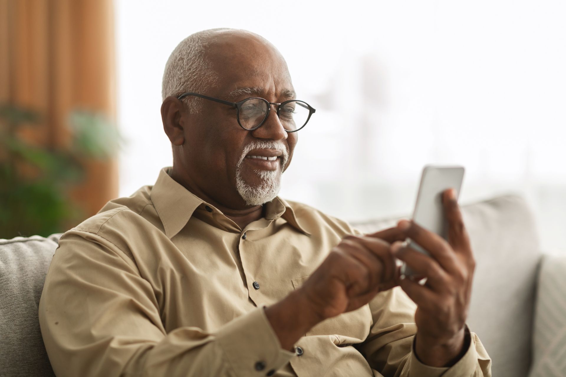 Senior man using LifeLoop application on smartphone at home
